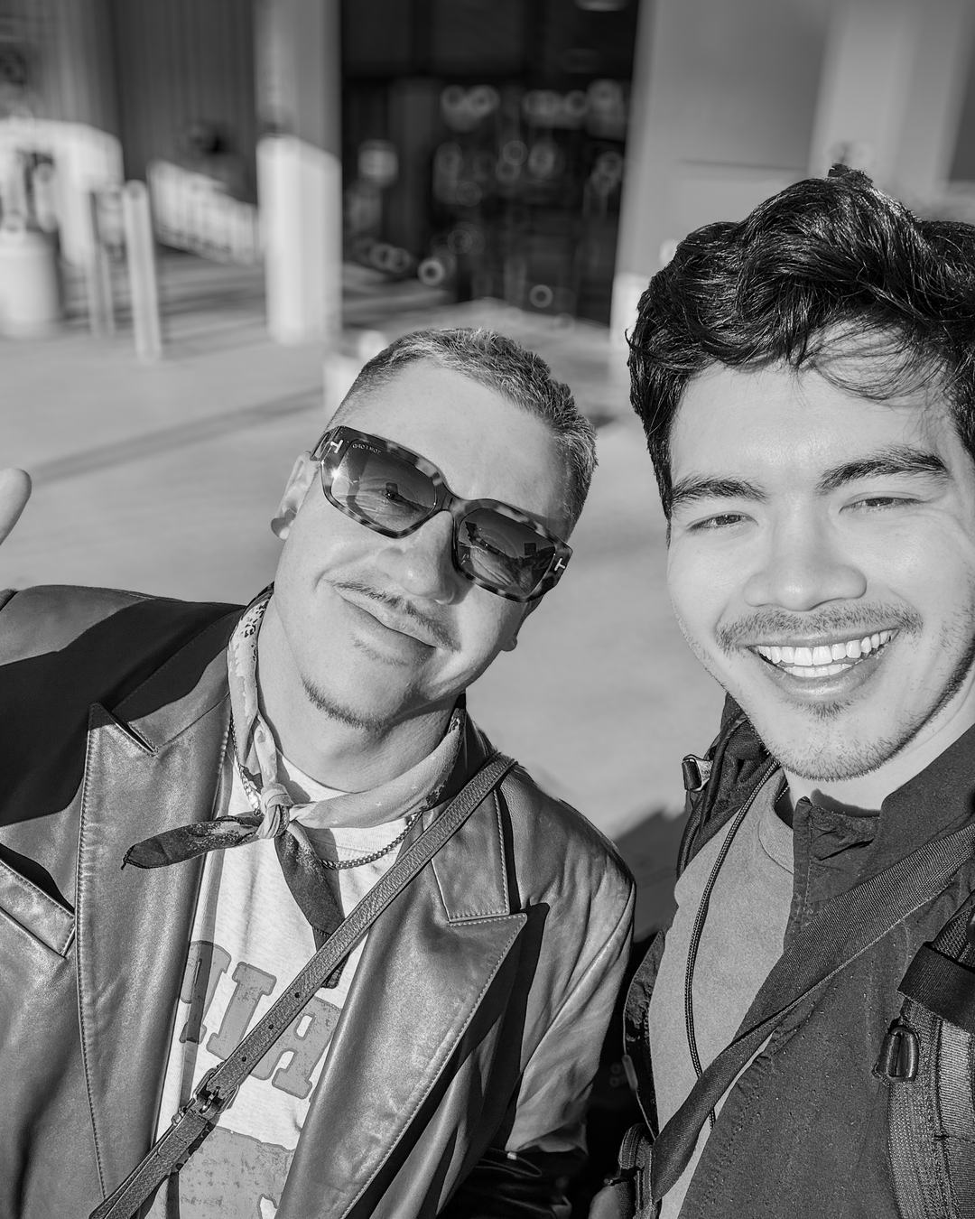 Black and white selfie of Charles and Macklemore smiling outside a venue