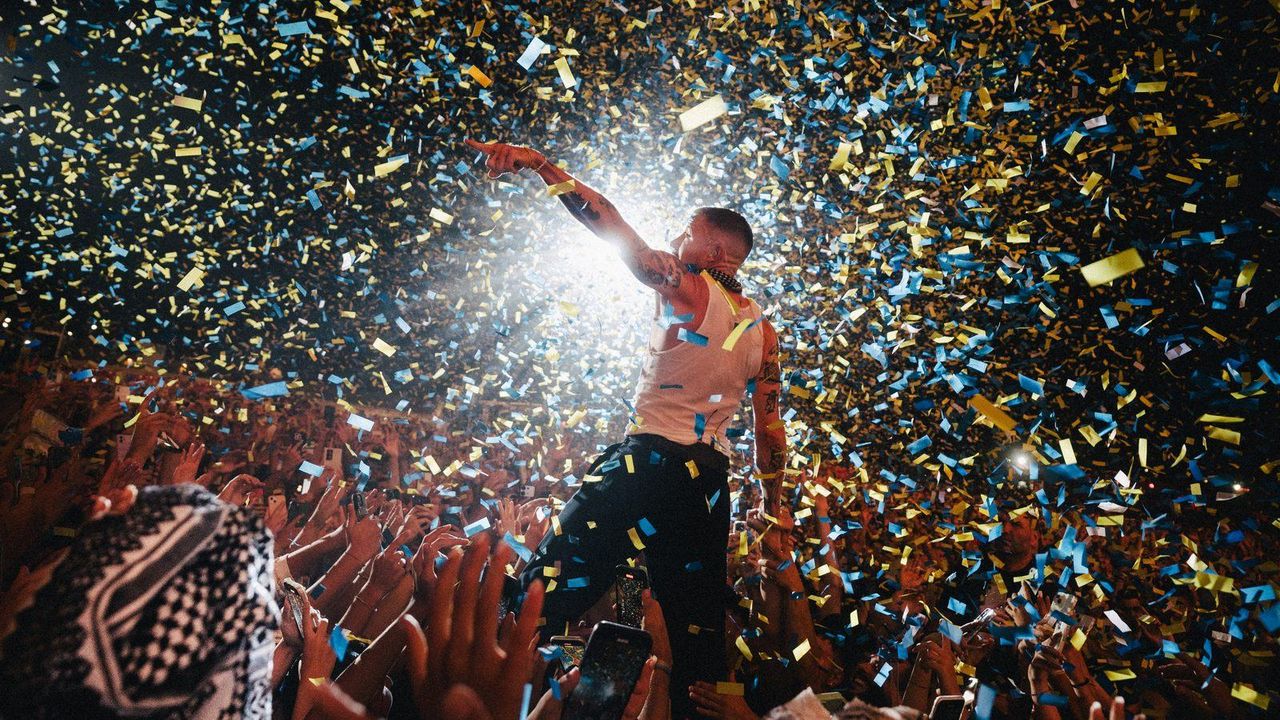Macklemore on stage under a storm of confetti on the BEN Tour